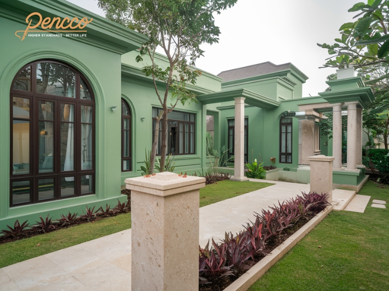 Ngoại thất biệt thự màu xanh ngọc với khung cửa tối màu.