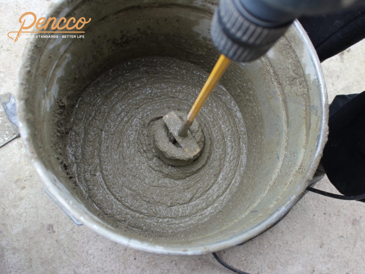 Trộn xi măng với nước để chuẩn bị pha sơn chống thấm