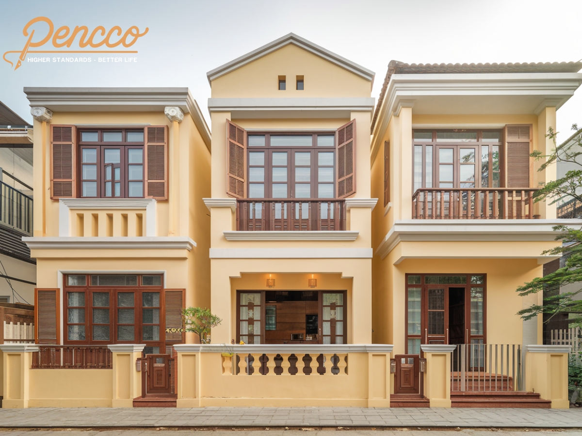 Nhà 2 tầng vàng kem - nâu ấm áp với ánh nắng sáng.
