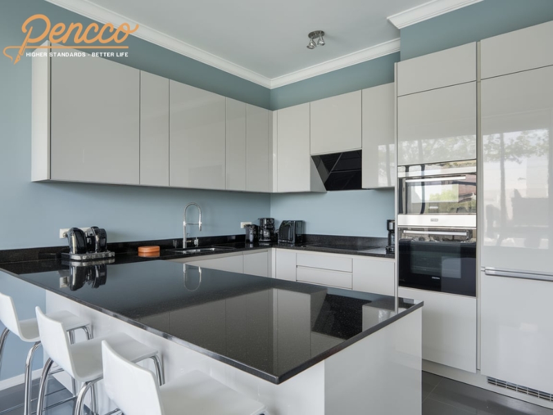 Nhà bếp màu xanh ghi với tủ acrylic bóng trắng và mặt bàn đá granite đen.